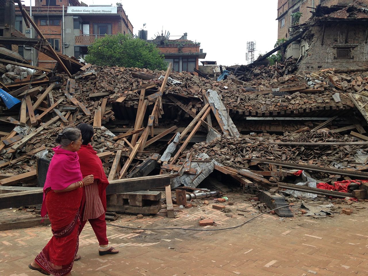 Women walk past buildings destroyed in Bhaktapuin by the April 2015 earthquake in Nepal