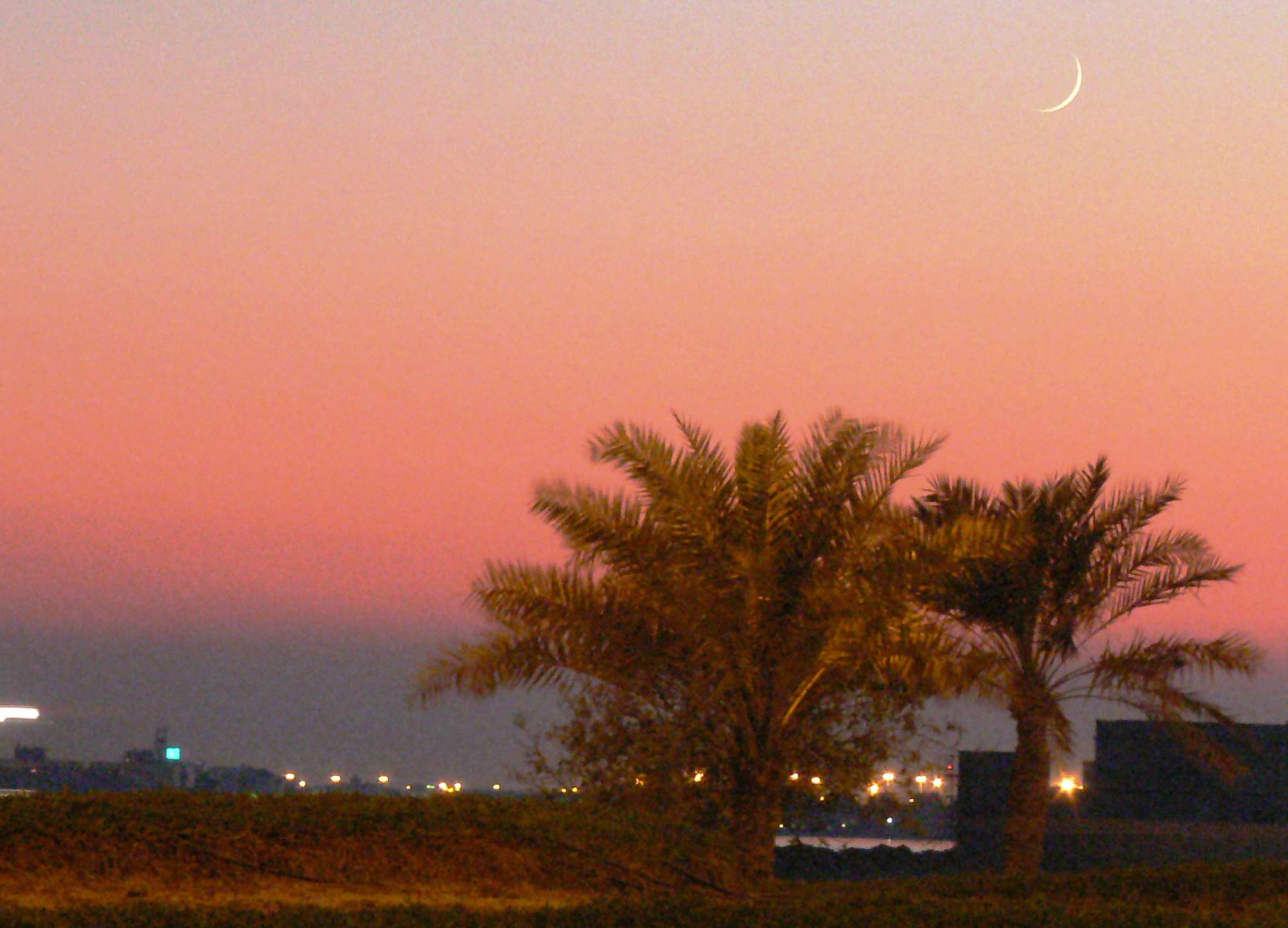 A crescent moon at sunset in Manama